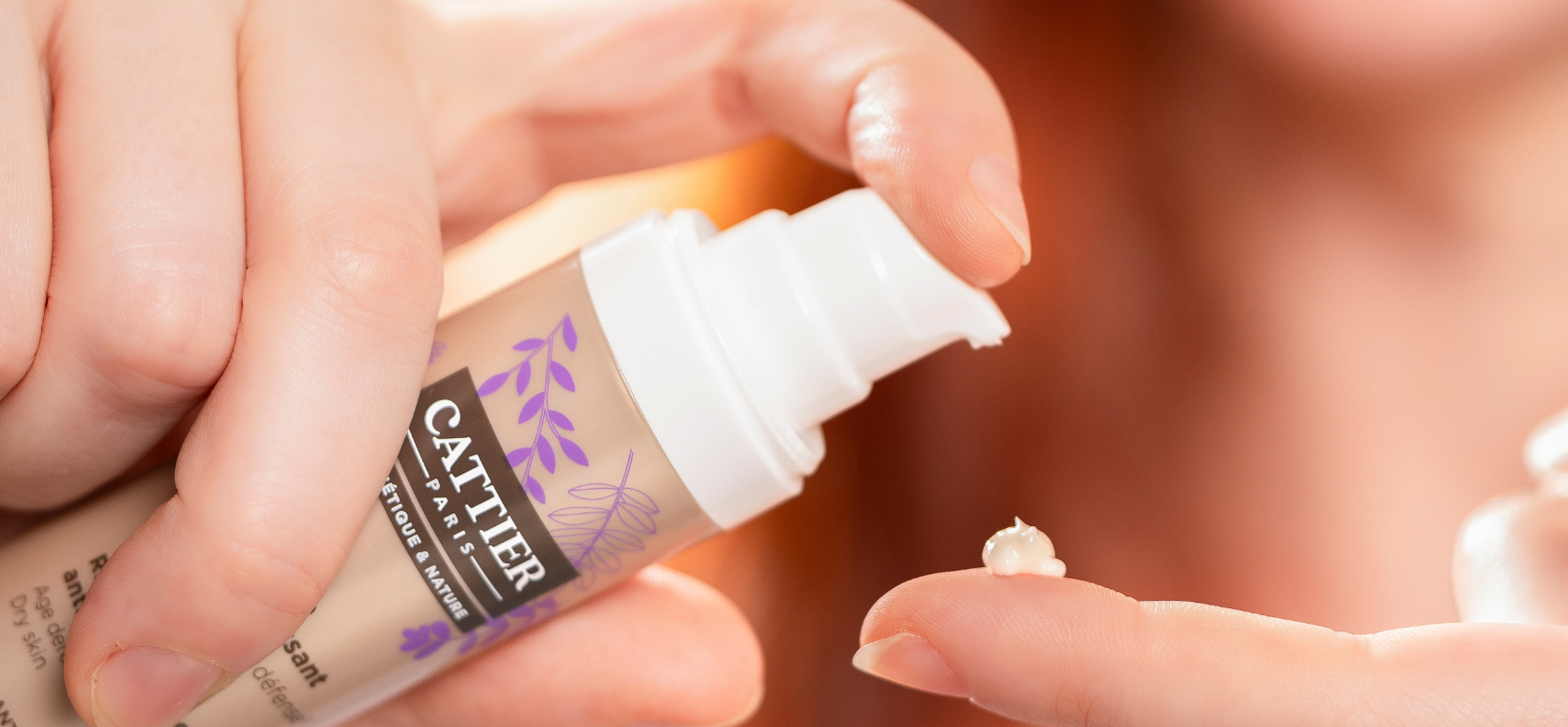 Visuel d'une femme s'appliquant le soin riche de jour anti-âge bio Cattier 