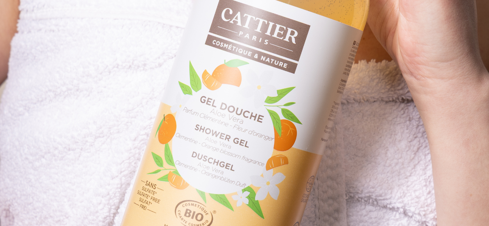 Visuel d'une femme avec le gel douche bio clémentine fleur d'oranger Cattier dans les mains