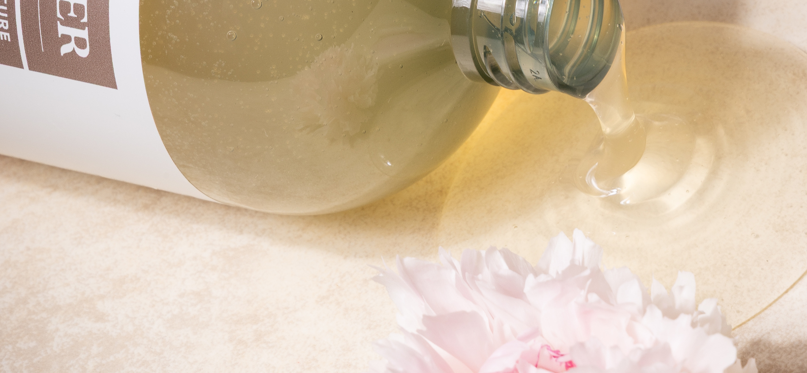 Visuel du gel douche bio rose pivoine Cattier qui coule avec une fleur