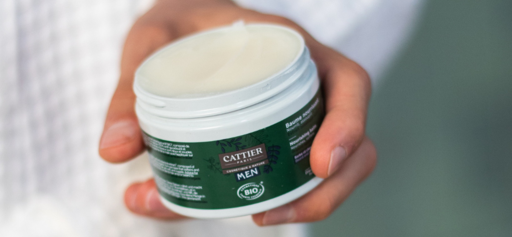 Visuel d'un homme prenant du baume nourrissant barbe et cheveux homme Cattier dans sa main 