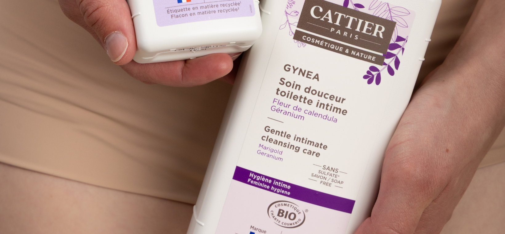 Visuel d'une femme en sous-vêtement tenant le soin douceur toilette intime Gynéa Cattier grand format dans la main 