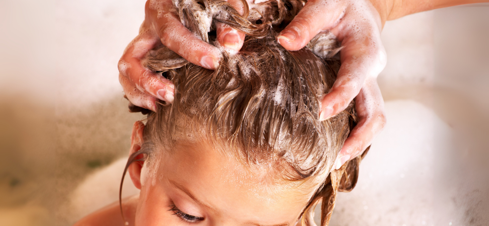 Visuel d'un enfant en train de recevoir un shampoing avec le shampoing bio 2 en 1 Cattier Fleur de guimauve
