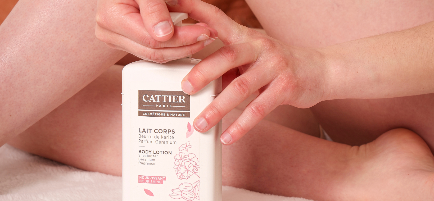 Visuel d'un femme appliquant du lait corps bio Cattier sur ses jambes parfum karité géranium