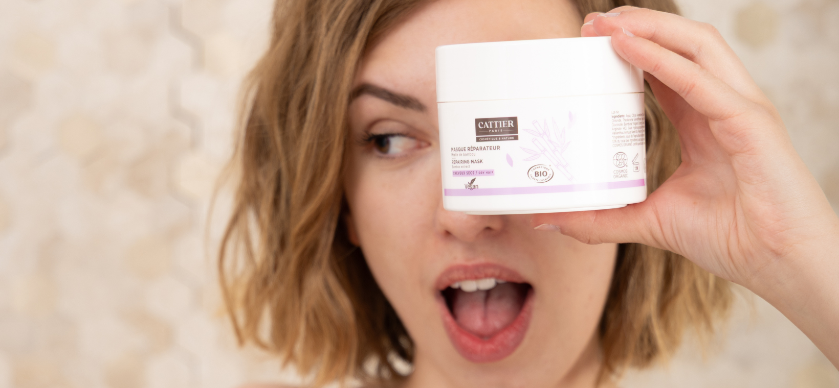 Visuel d'une femme tenant le masque cheveux secs bio Cattier devant son visage