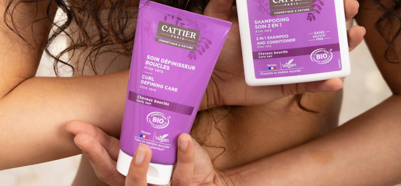 Visuel d'une femme tenant le soin définisseur de boucles bio Cattier