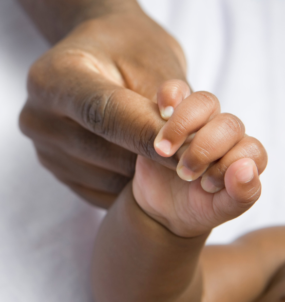 Main de bébé fermée autour du doigt de maman pour illustrer la maternité