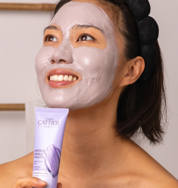 Visuel d'application du masque à l'argile violette sur le visage d'une femme